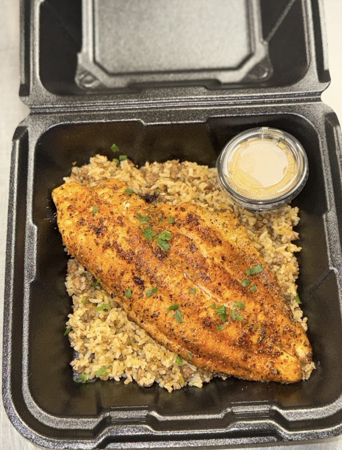 Blackened fish over dirty rice with cajun aioli